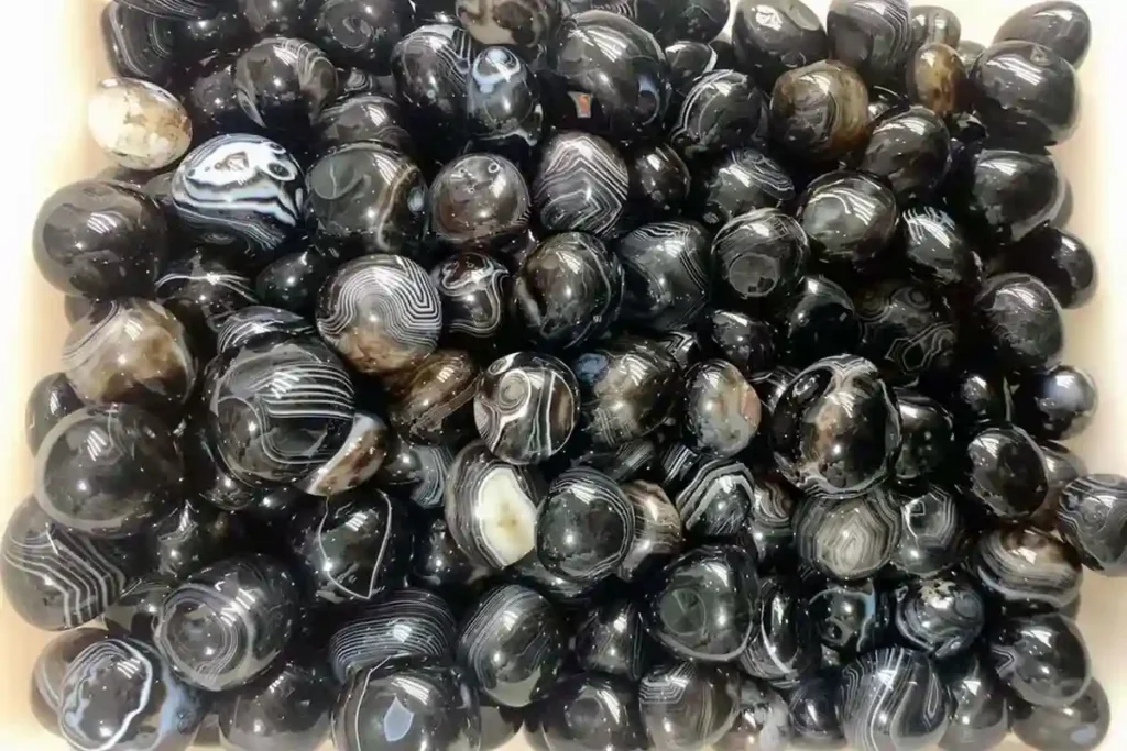 Polished Black Onyx tumbled stones (20–30mm) used for healing, balance, and emotional stability — discover the true Black Onyx Benefits.