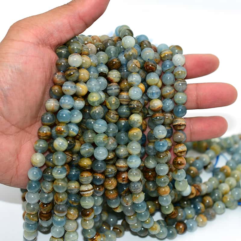 Blue Calcite Beads held in hand to show size, smooth surface, and craftsmanship