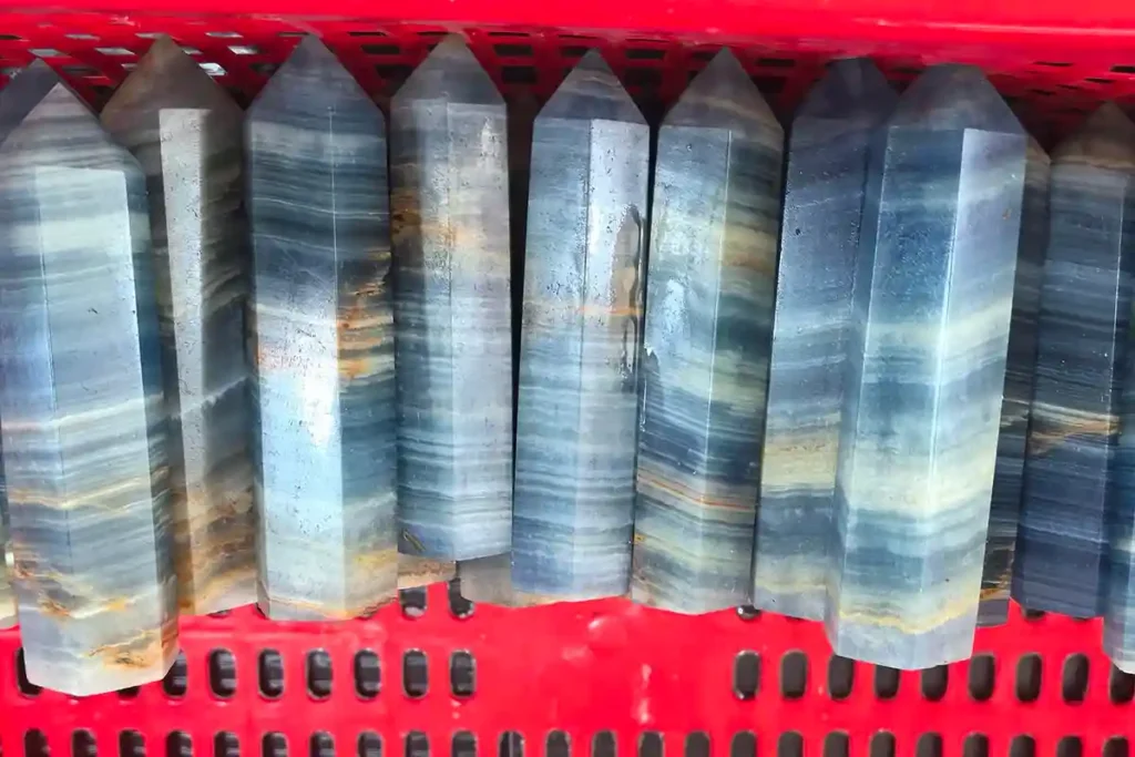 Blue Calcite Meaning – Polished Blue Calcite Towers in basket, representing clarity, peace, and emotional healing energy.