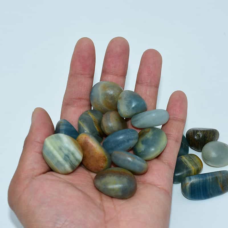 Blue Calcite Tumbled stones 20–30mm displayed on hand, showing natural blue tone and smooth polish.