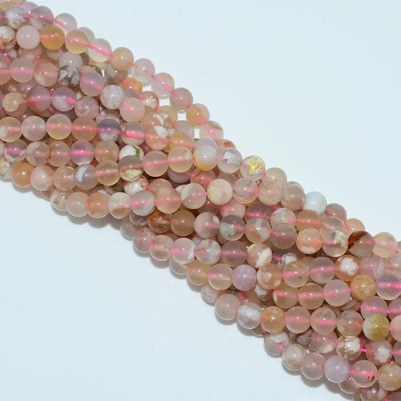 Top-down photo of flower agate beads strands arranged neatly, revealing uniform size and glossy finish for bulk buyers.
