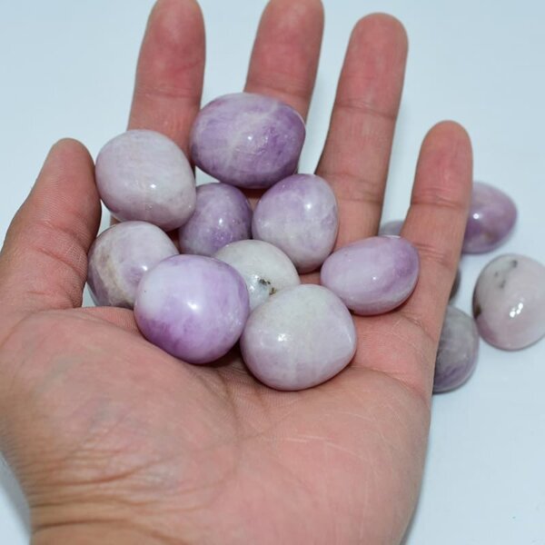 kunzite tumbled stone on hand showing size and natural lilac color
