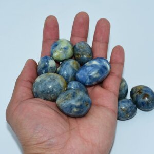 Close-up Kyanite Tumbled stones held in hand for scale