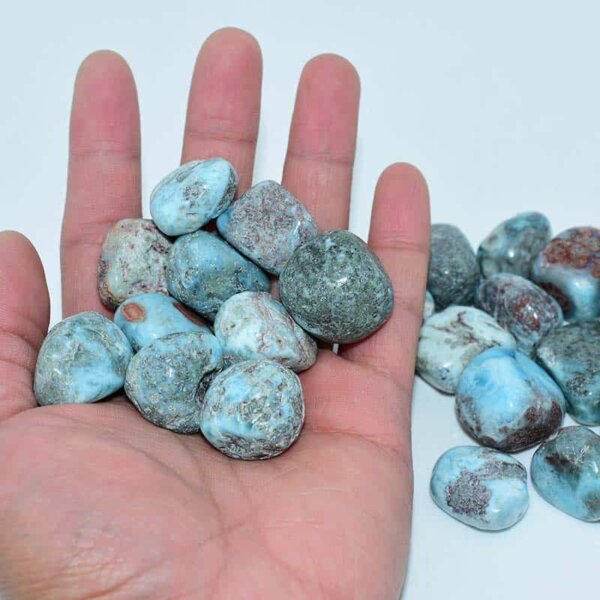 Larimar Tumbled Stone placed on hand to show natural texture and size