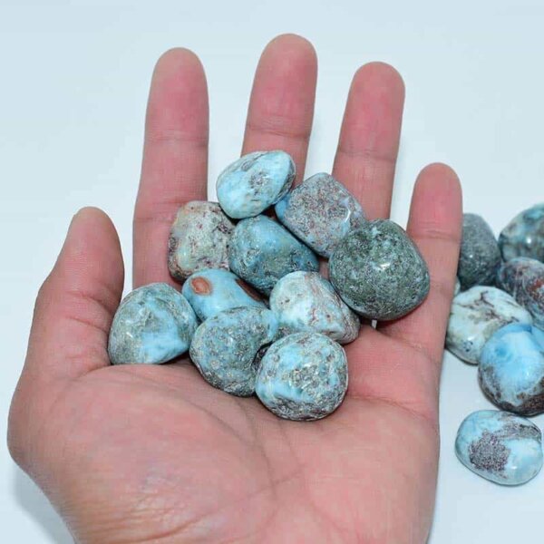 Hand holding Larimar Tumbled Stone with detailed surface visible