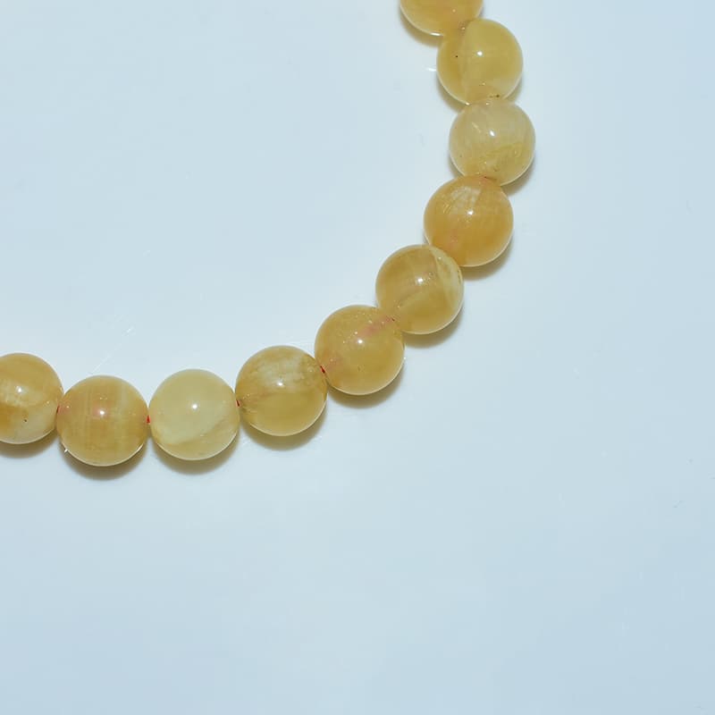 Orange Calcite Bracelet details showing natural translucent texture and inner silk threads