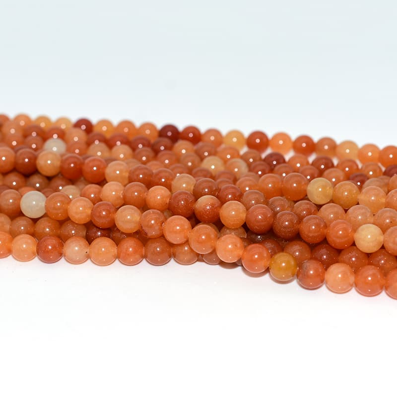 Close-up detail of Red Aventurine Beads showing orange-red sparkle and smooth polish