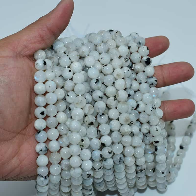 White Labradorite Beads on hand displaying luster and round bead shape