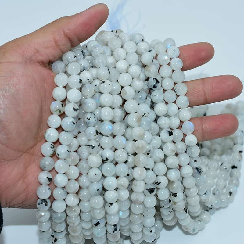 White Labradorite Beads strand on hand showing natural blue flash and texture