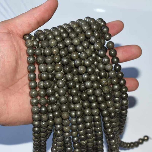 pyrite beads on hand—natural golden sheen shown in daylight, dense weight and
