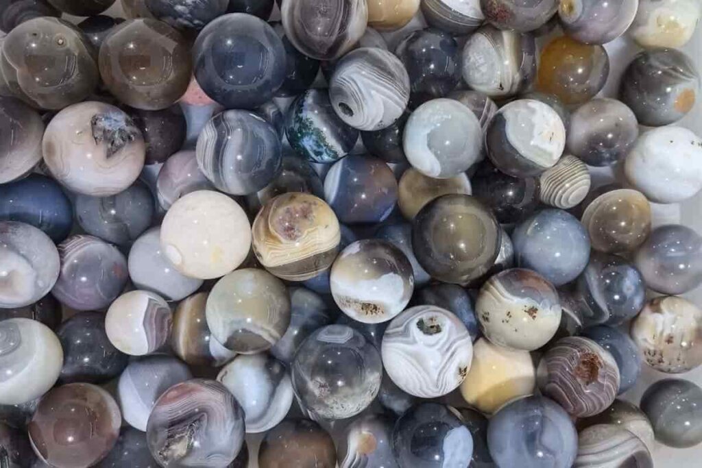 Polished Botswana Agate gemstone ball reflecting the Botswana Agate meaning of emotional healing and inner peace.