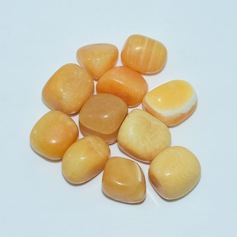 Top view of Orange Calcite Tumble stones highlighting polish and glow