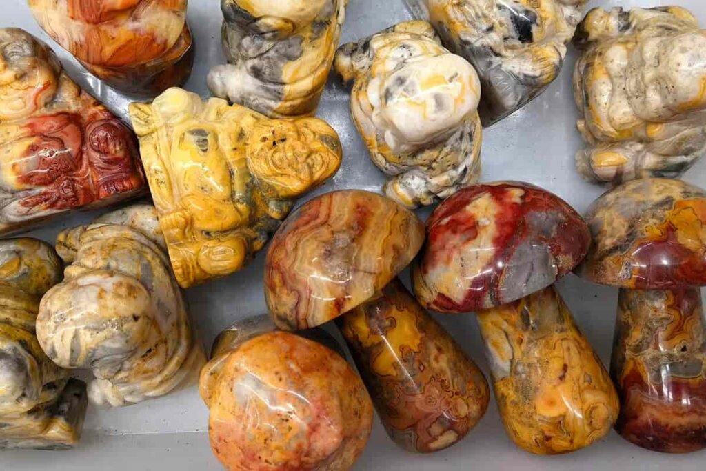 Carved Crazy Lace Agate pieces showing natural banding patterns, illustrating Crazy Lace Agate Meaning in decorative crystal carvings.