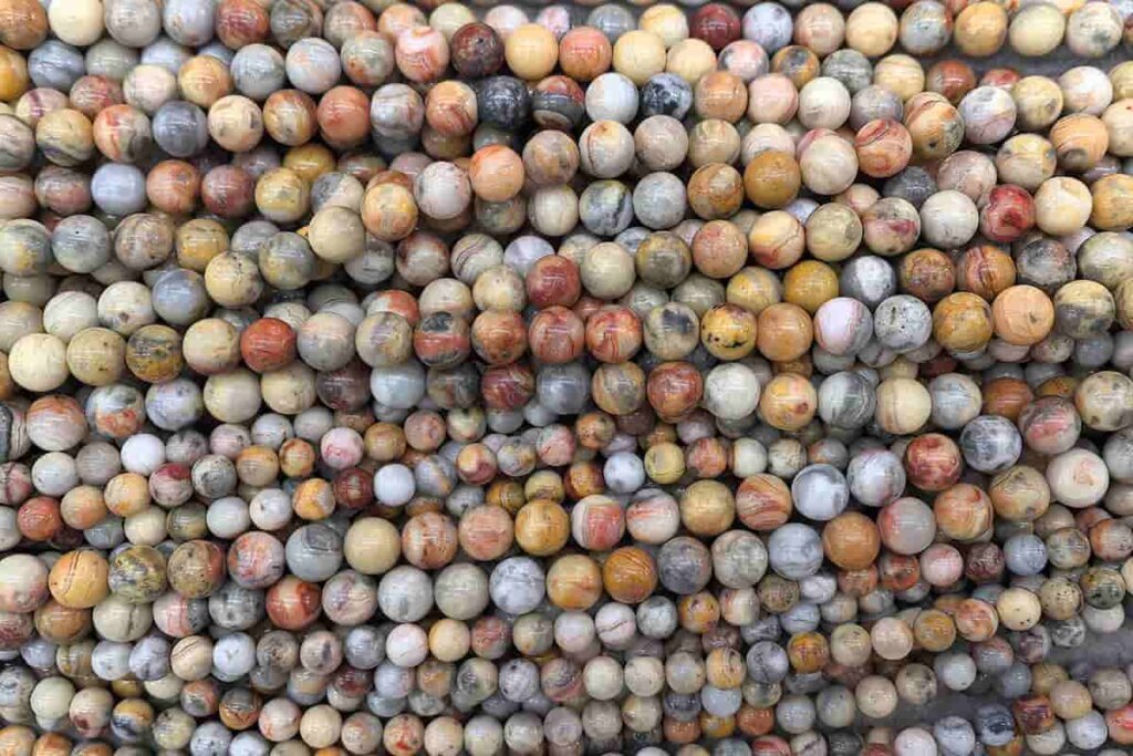 Crazy Lace Agate strand beads with detailed banding, used in jewelry making and connected to Crazy Lace Agate Meaning in handcrafted designs.