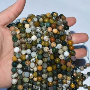 Ocean Jasper Beads bulk strands displayed on hand