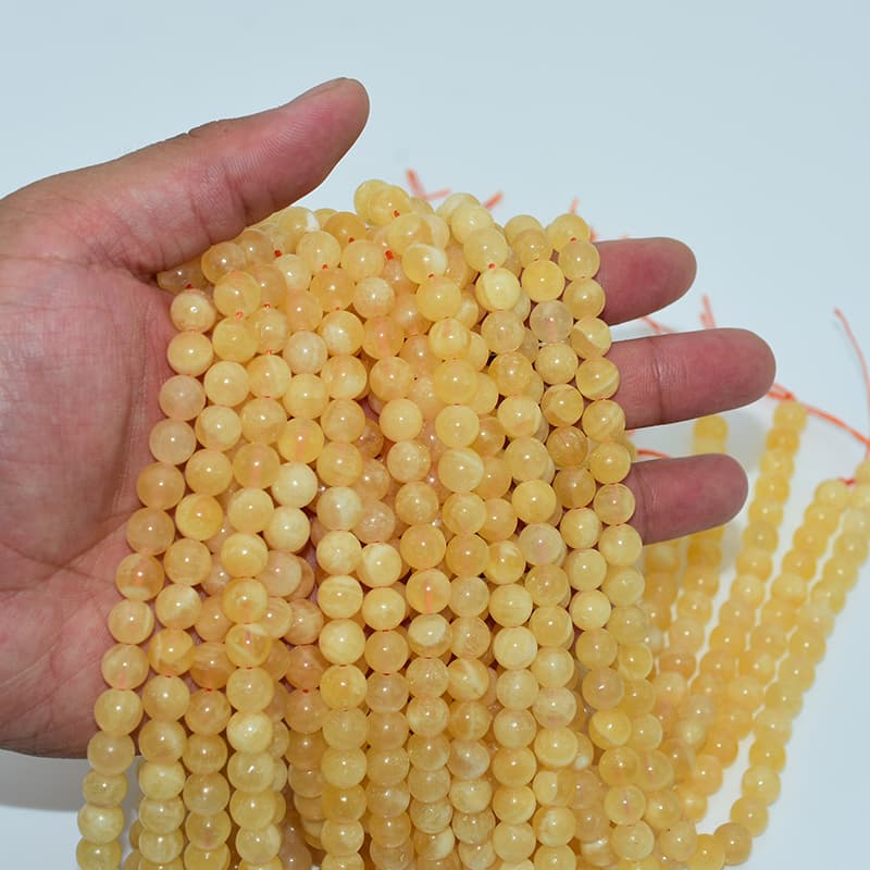 Orange Calcite Beads 8mm strands in hand for wholesale quality check