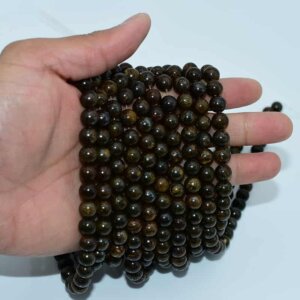 Bronzite Beads displayed on hand to showcase size and texture.